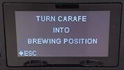 Turn carafe into brewing position